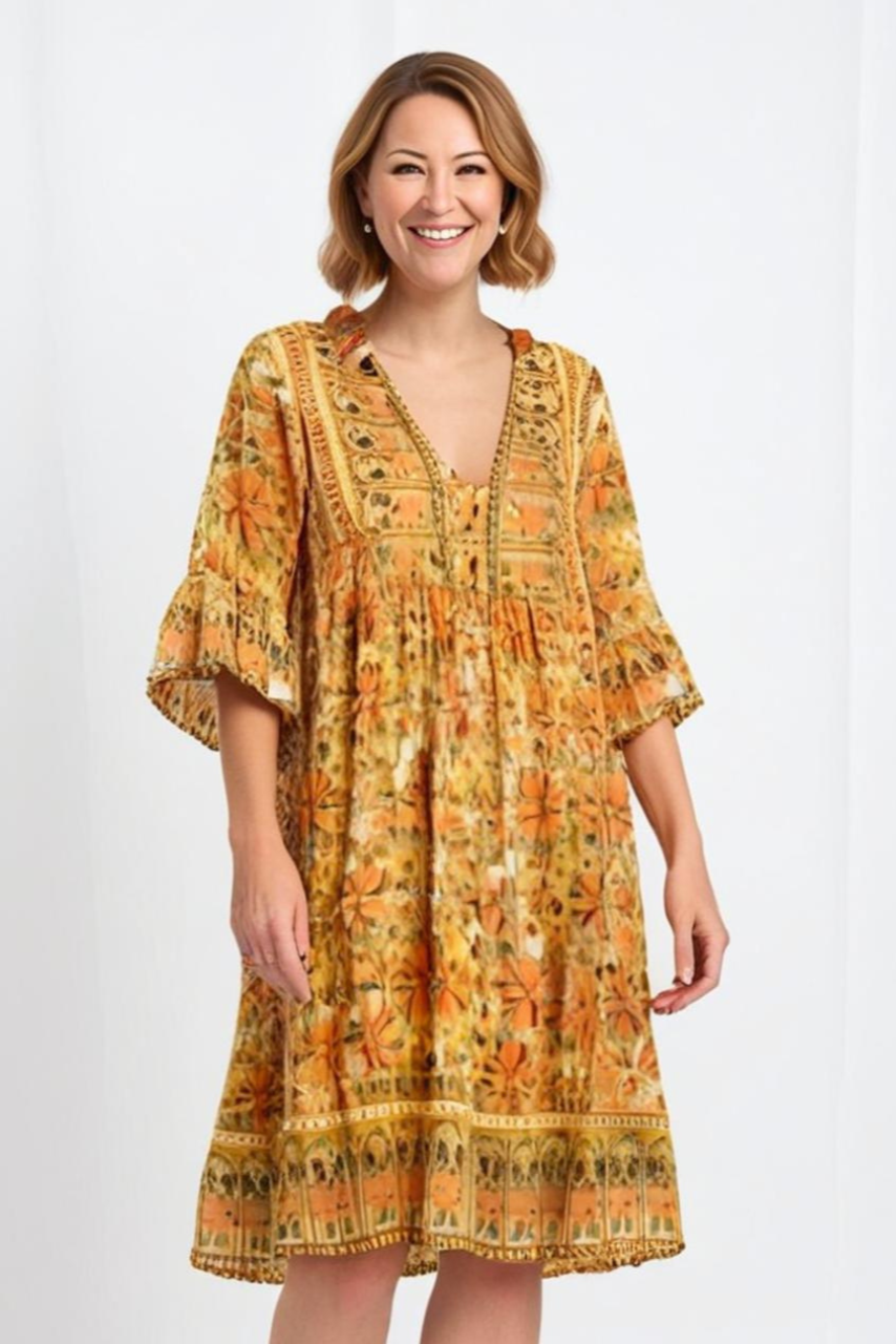 Woman wearing a yellow patterned dress on a white background
