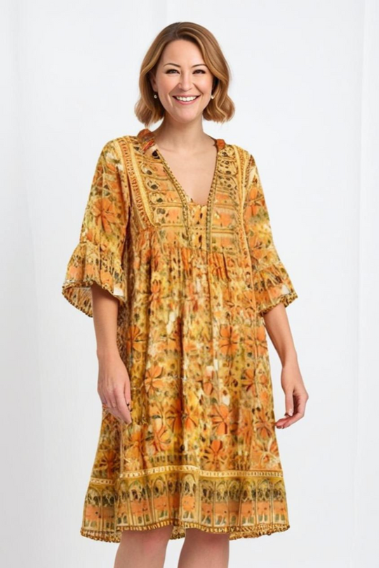 Woman wearing a yellow patterned dress on a white background