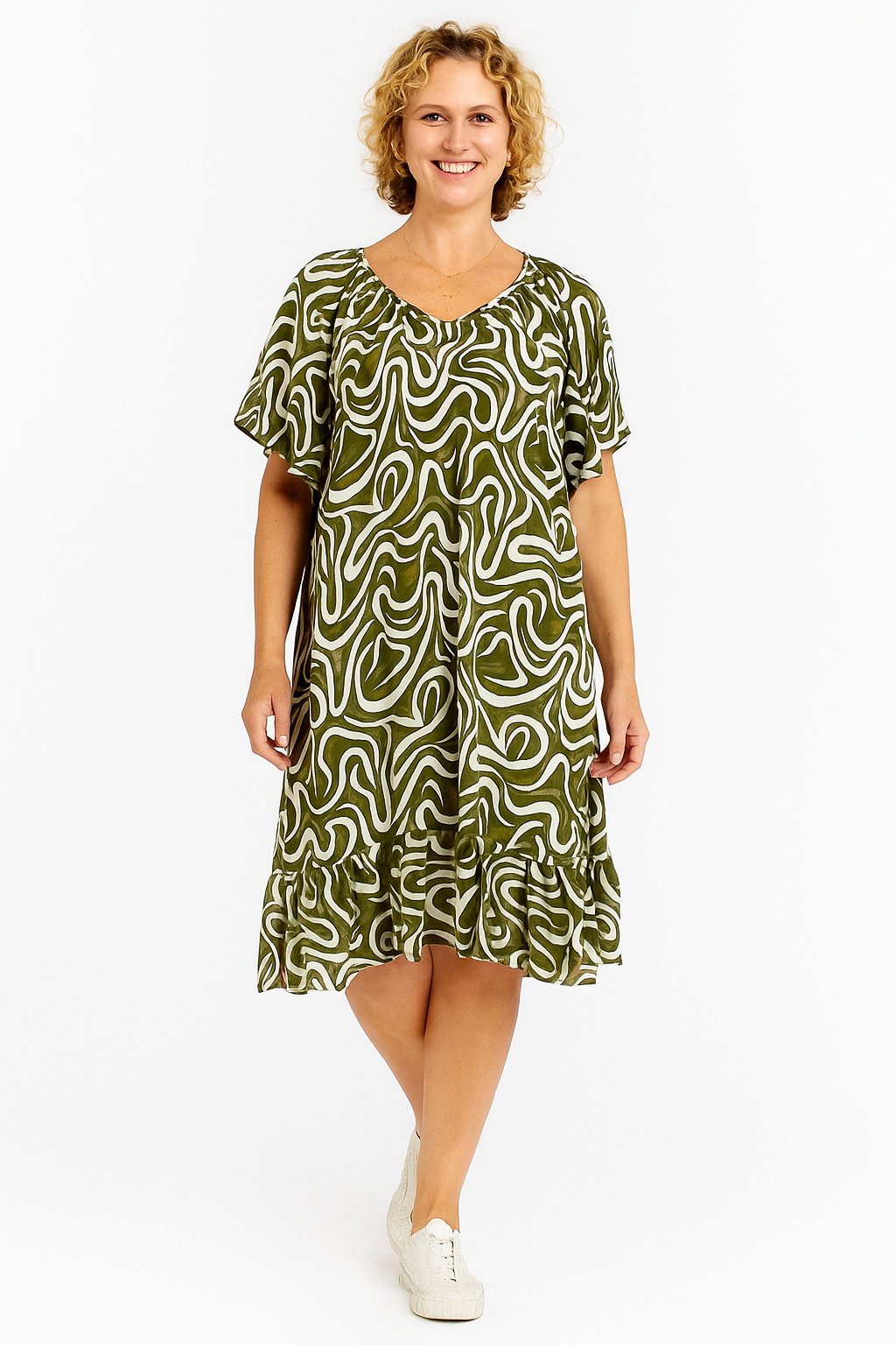 Woman wearing a green patterned dress on a white background