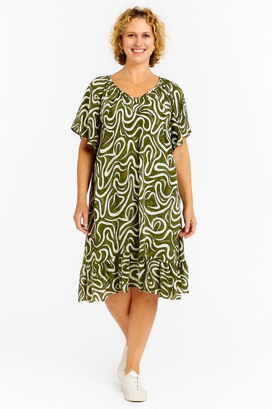 Woman wearing a green patterned dress on a white background